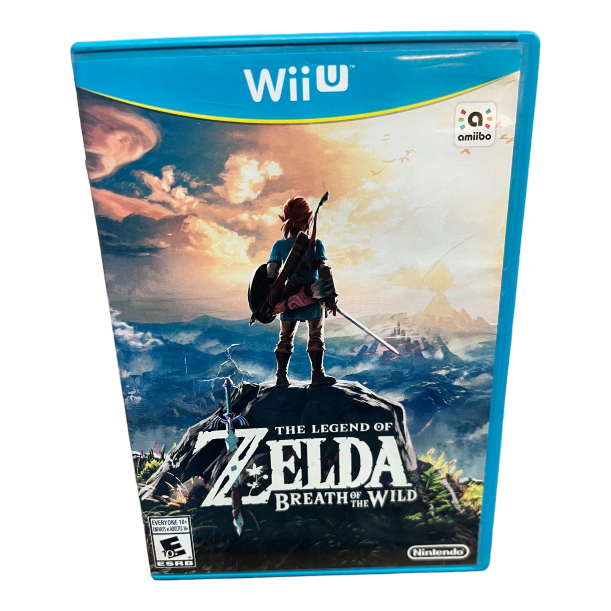 The image shows the physical product of 'The Legend of Zelda: Breath of the Wild' for Nintendo Wii U. It features the game's cover art with the character Link on a mountain top with a expansive landscape in the background.