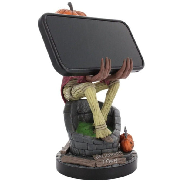 Sculpture of a skeleton holding a smartphone with pumpkins on a white background