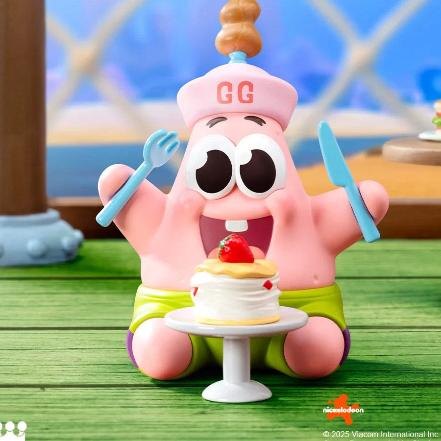 Pink cartoon character with a cake and utensils on a wooden surface