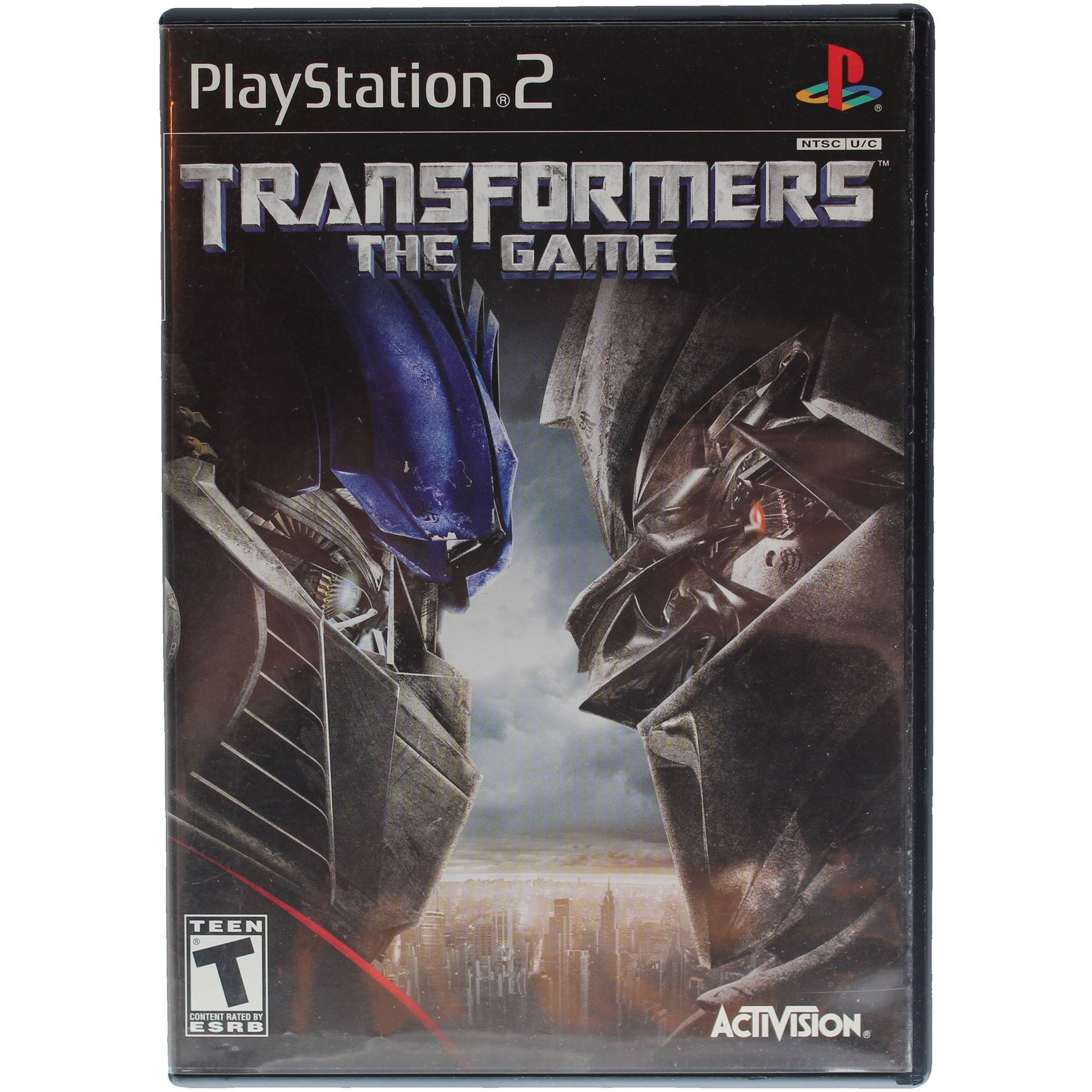PlayStation 2 game case for 'Transformers: The Game' with two robot figures facing each other.